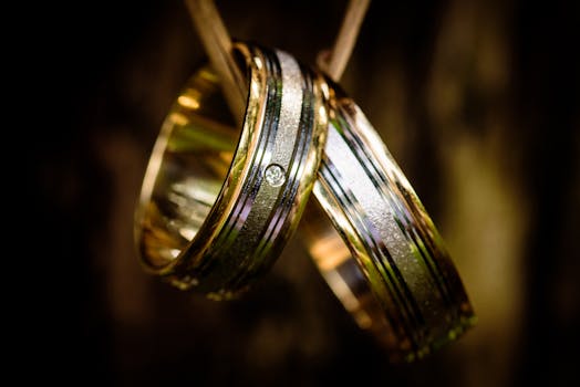 Prsteny Close-up of luxurious gold wedding rings with a diamond detail, perfect for wedding themes.